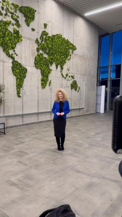 Branislava Lovre filming in front of a moss world map installation